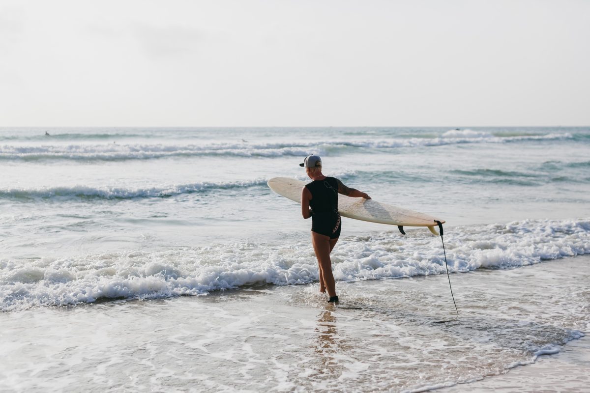 surfing woman with surfing board back view